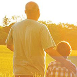Man and boy standing looking at a field