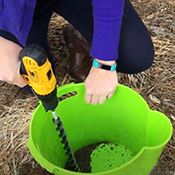 Soil testing the lawn by using a drill and a bucket